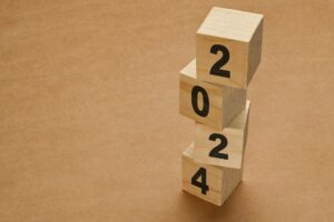 2024 numbers on wooden cube blocks stack on brown background.
